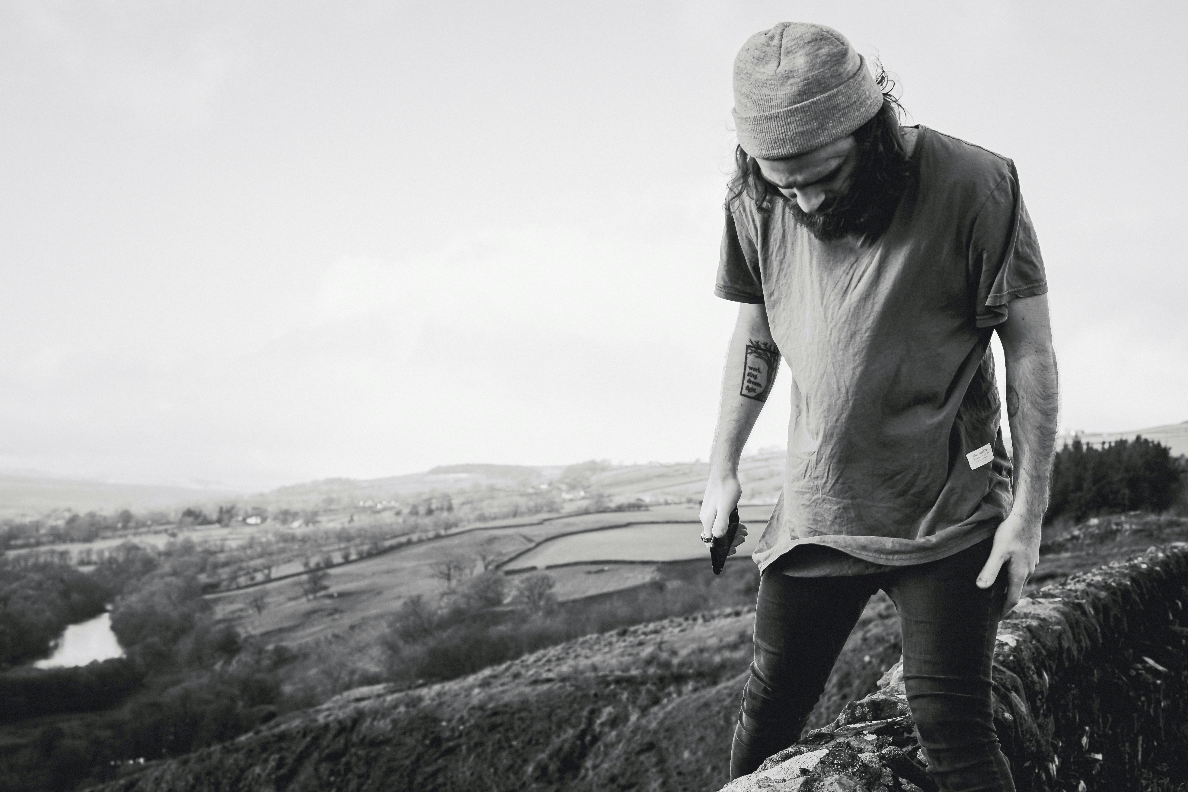 grayscale photography of man on top of trees